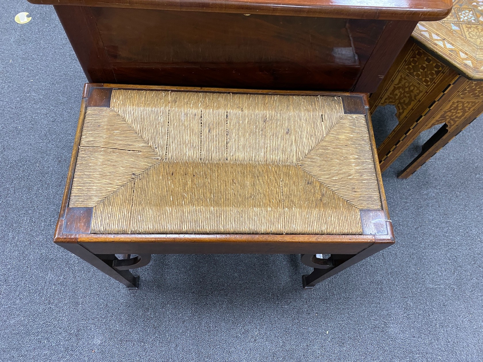 An Arts & Crafts mahogany stool with drop in rush seat, width 61cm, depth 34cm, height 53cm.